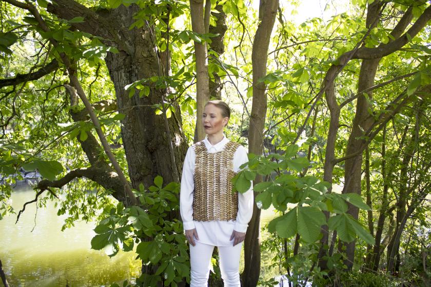 Person standing among trees and wearing a wooden garment