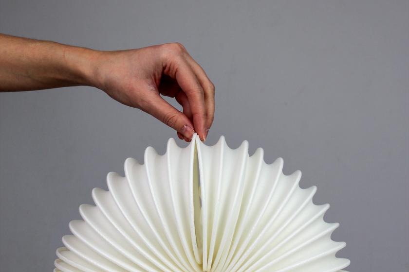 Hand holding a white 4D printed structure